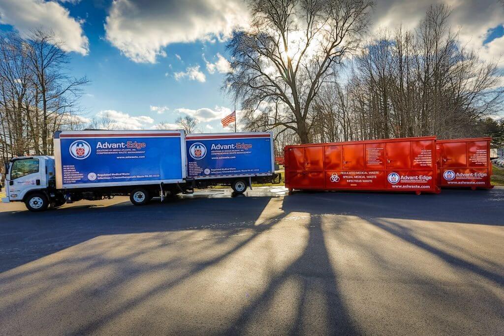 ASMAI trucks and dumpsters in a parking lot