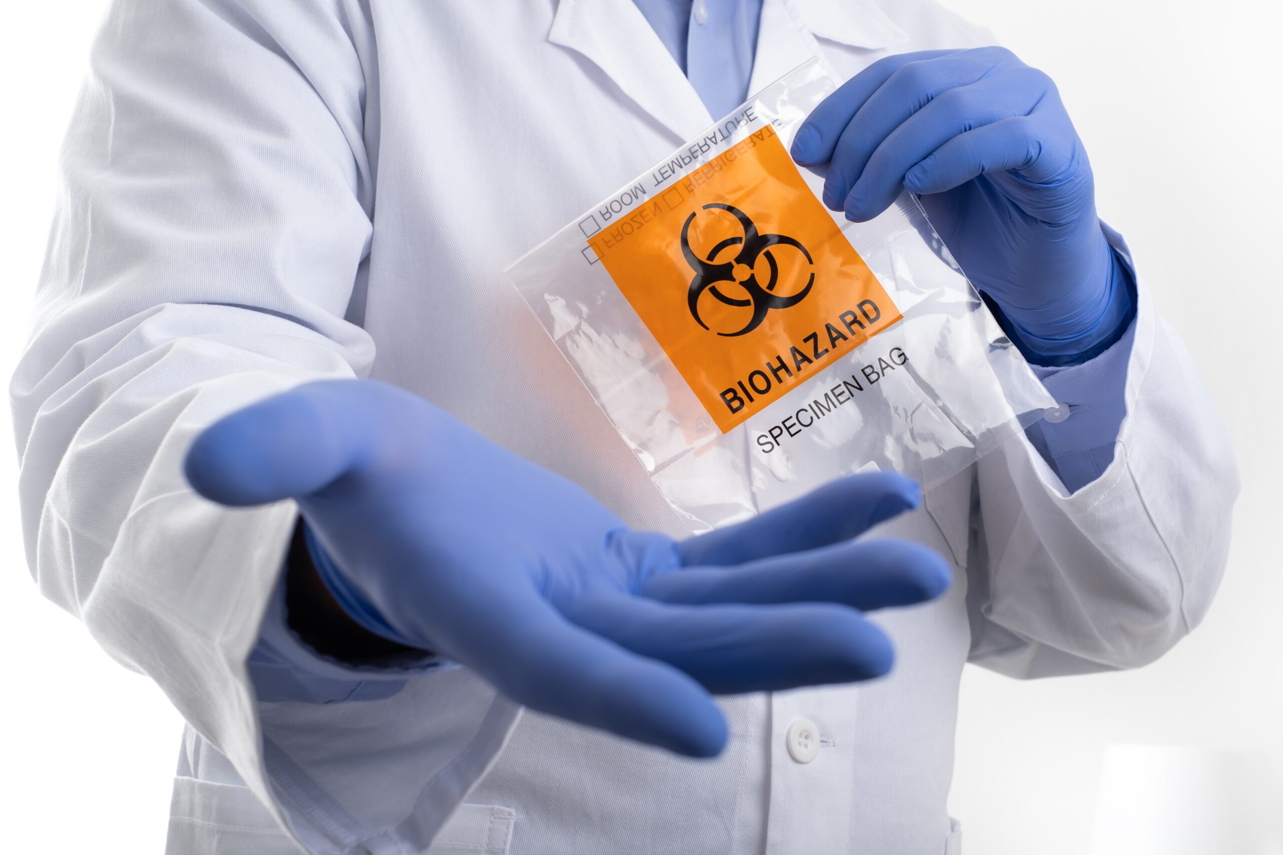 image of a doctor holding a biohazard bag with gloves on